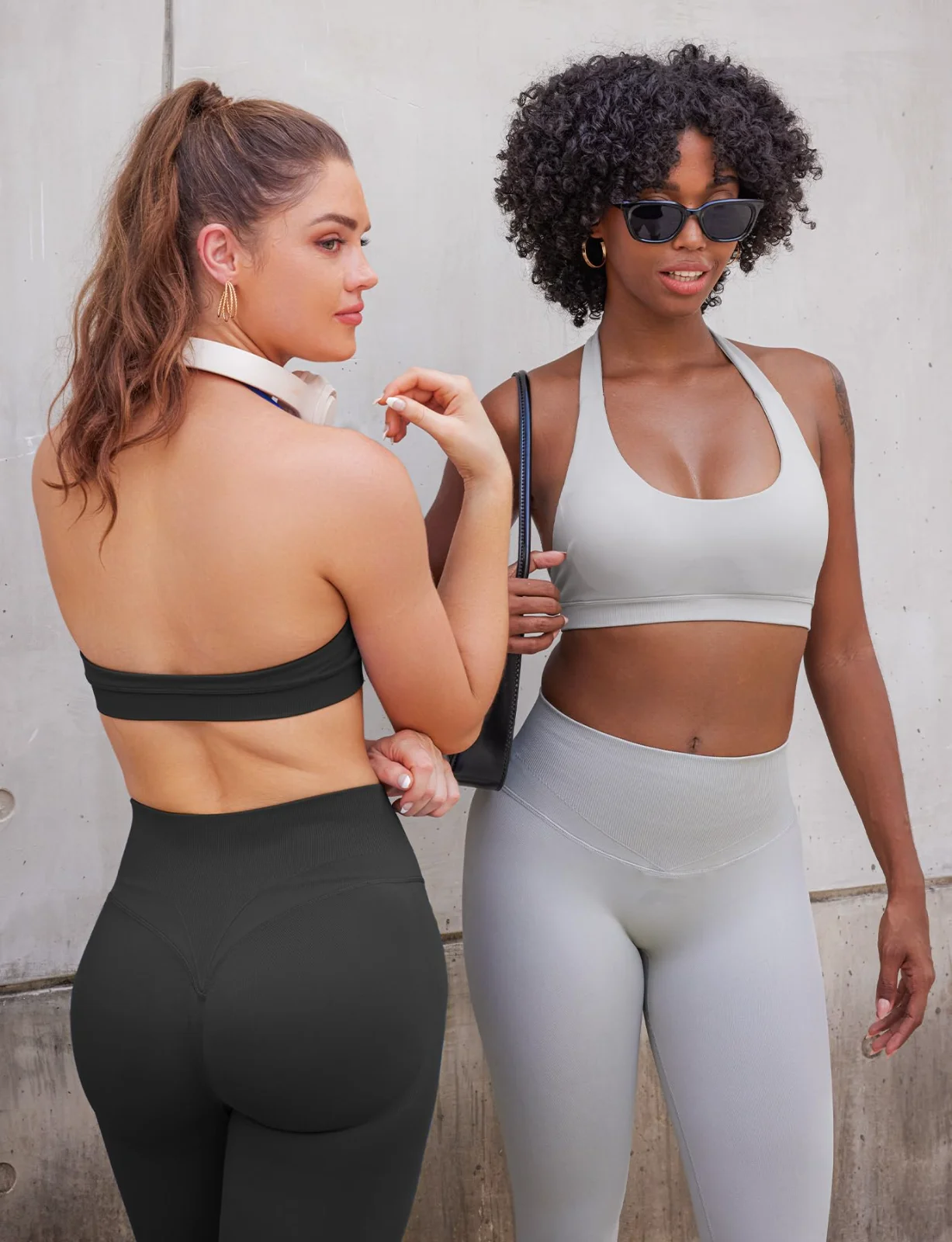 Two halter bras side by side, one black and one white, on a rooftop in sunglasses