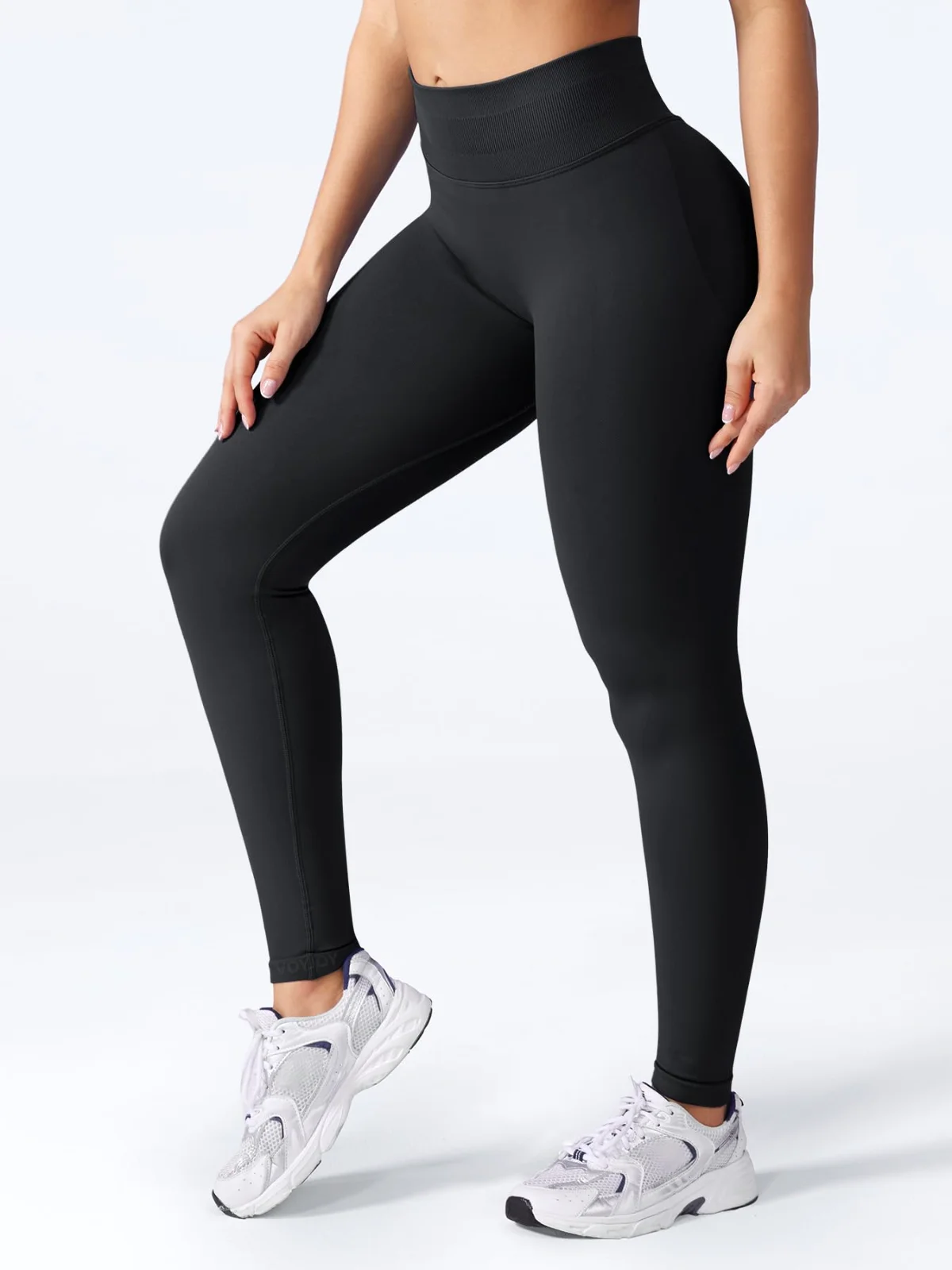 Black impact leggings walking towards the camera in white trainers, the knit smooth down the front of the leg